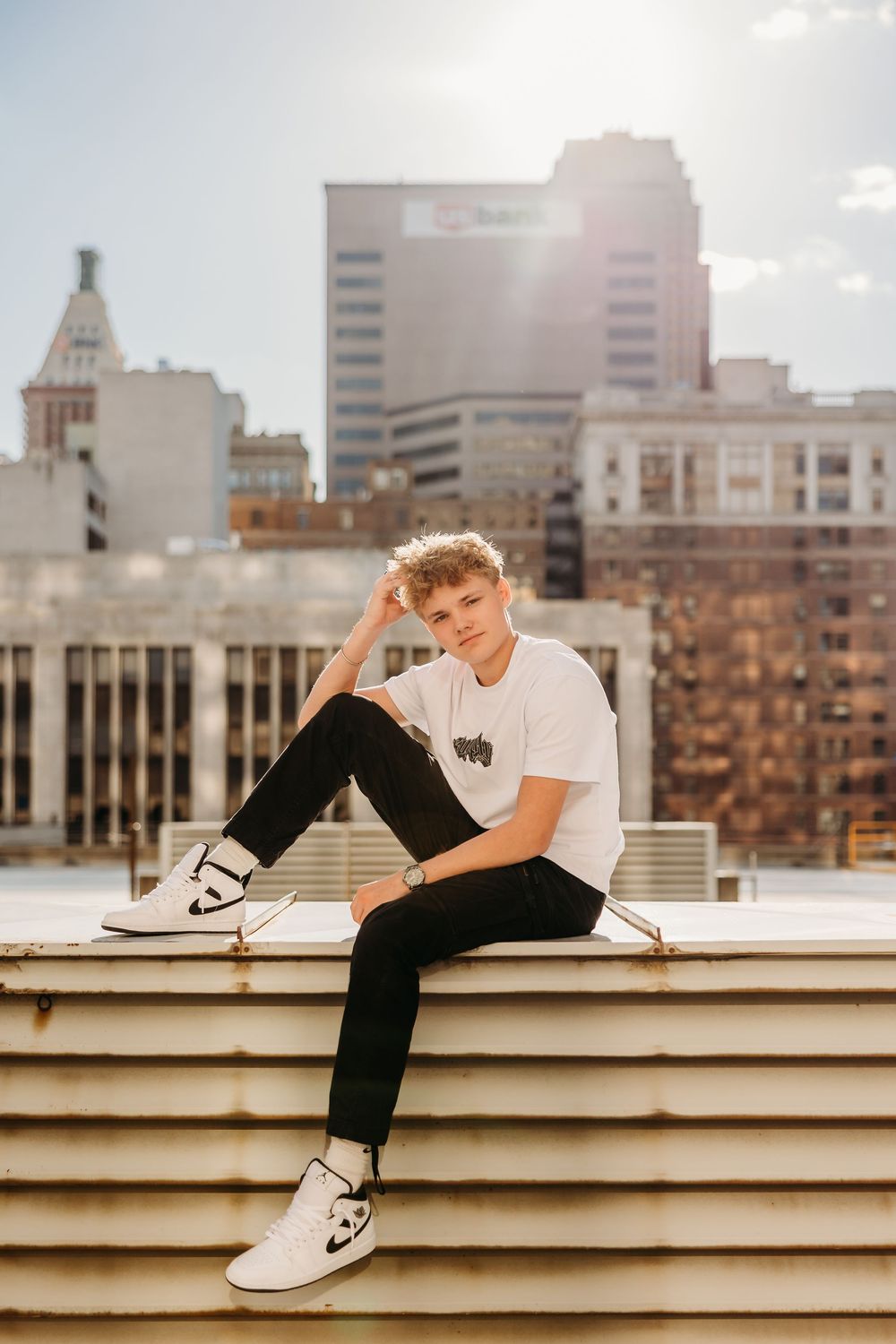 Senior boy on top of rooftop in downtown Cincinnati with golden light. Cincinnati, Northern Kentucky, and Chicago Portrait Photographer