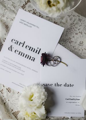 Elegant wedding invitation suite for Carl Emil and Emma featuring save the date card with rings and white flowers.