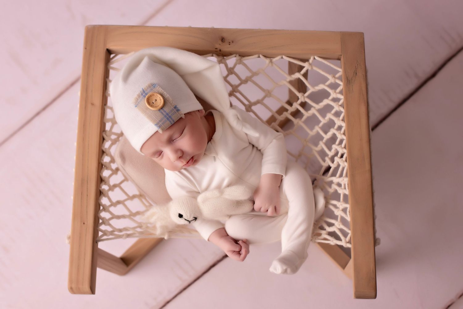 Peaceful sleeping infant wrapped in dark green knit blanket.