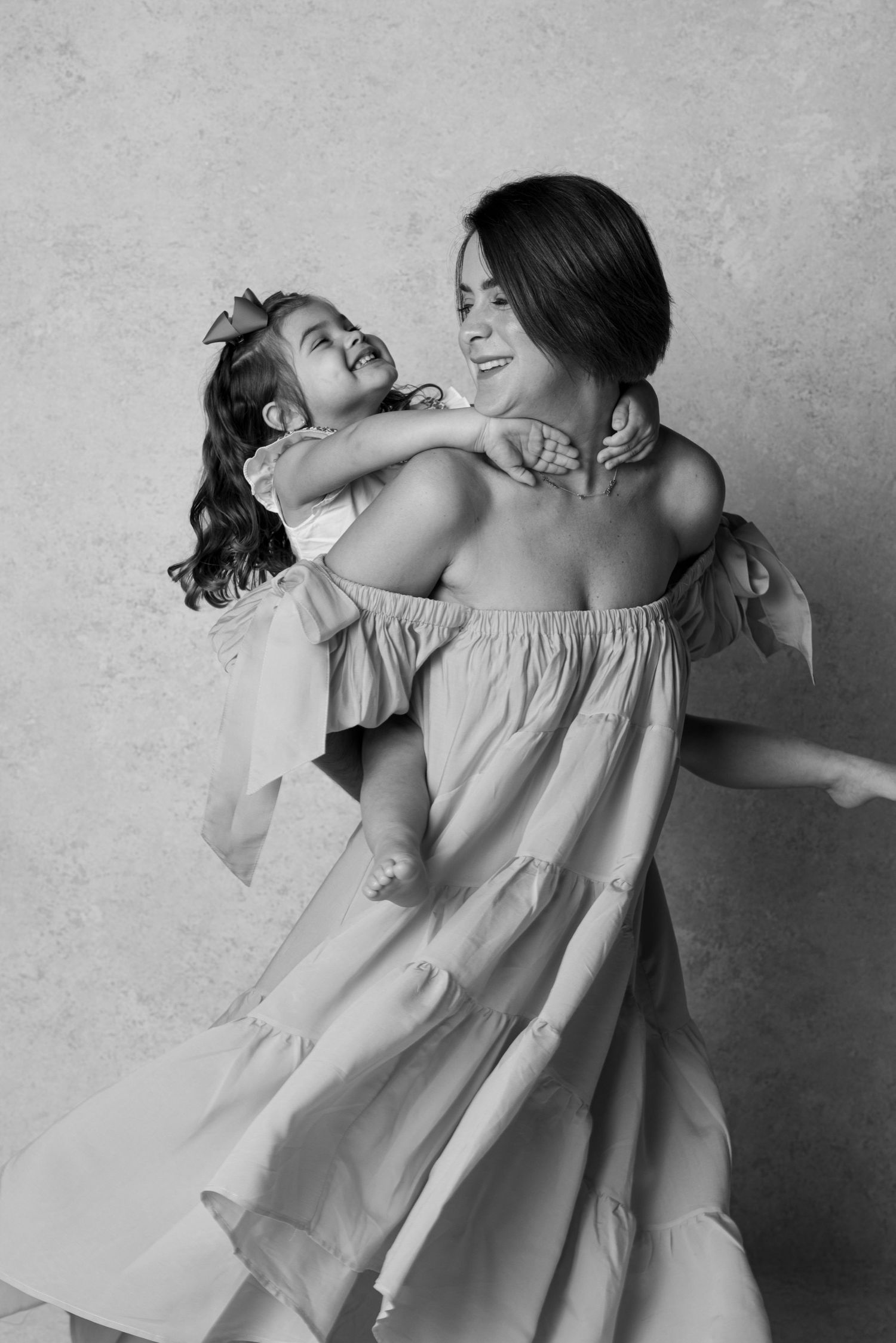 Parent and child share joyful moment in black and white portrait.