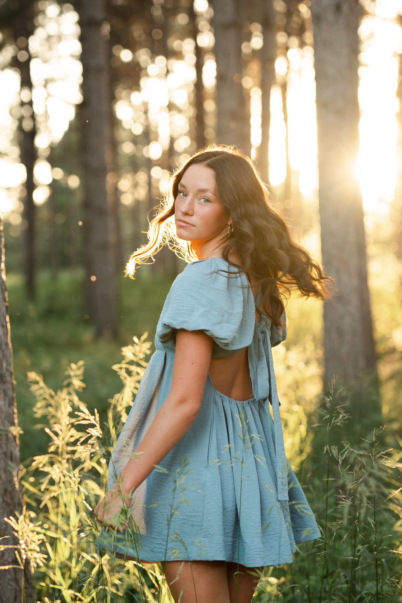 Senior looking over shoulder at camera. Captured at Montissippi Park by Shania hirdler Photography