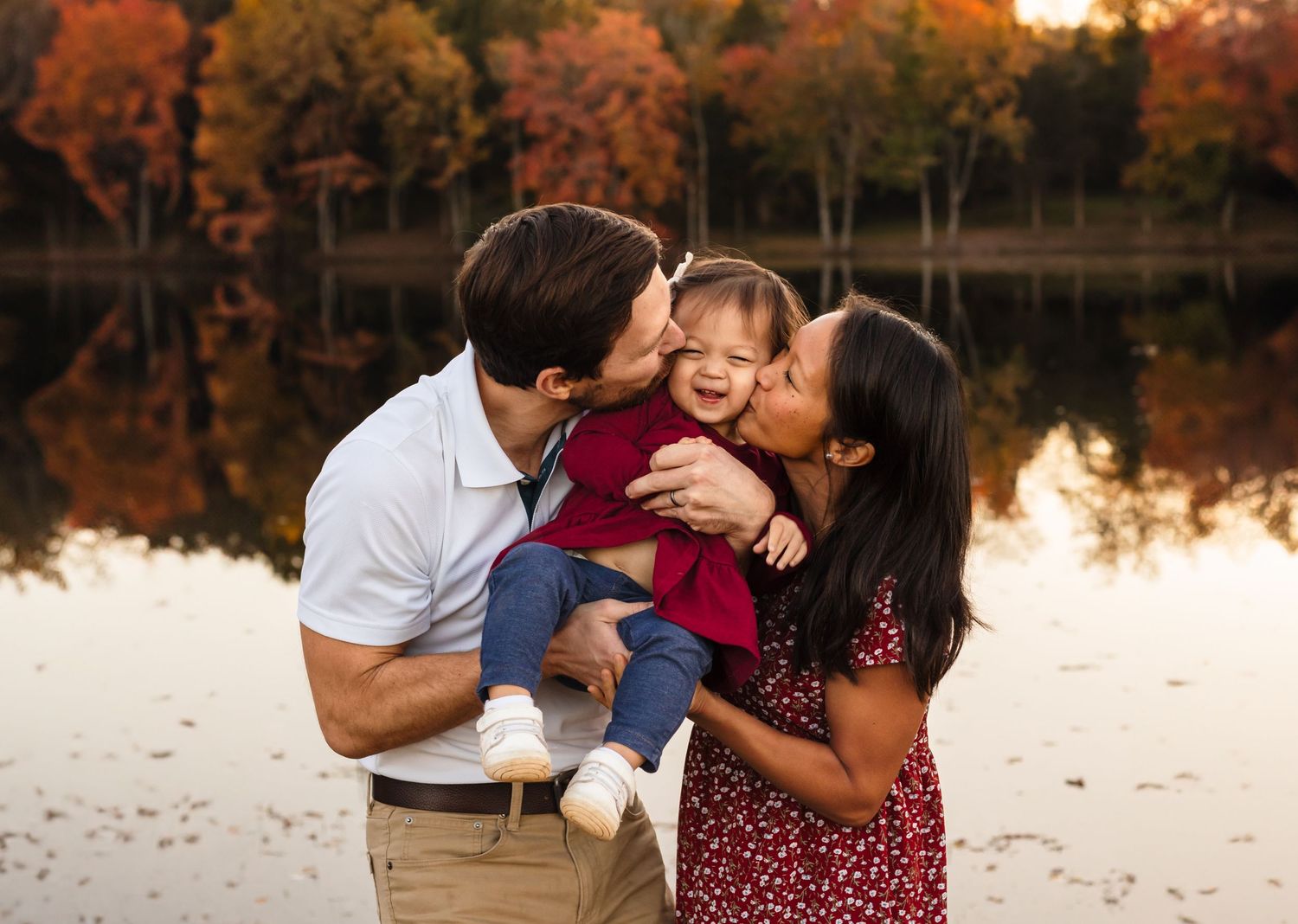 Charlottesville photographer, family, baby, newborn, maternity, couple kissing daughter against gorgeous fall backdrop