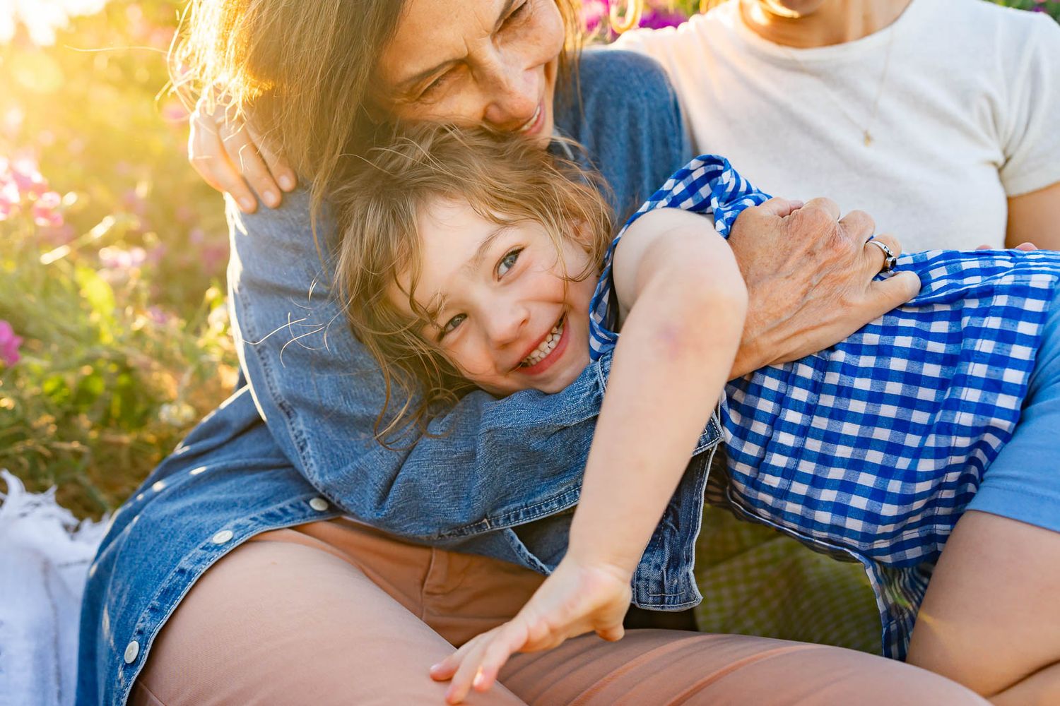 Grandma plays with her granddaughter at sunset in Discovery Park.
