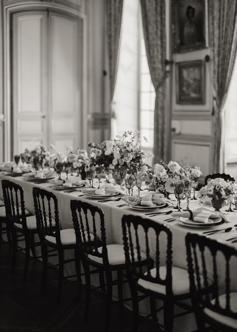 Classic dining room setup with long tables and dark chairs in a formal setting.