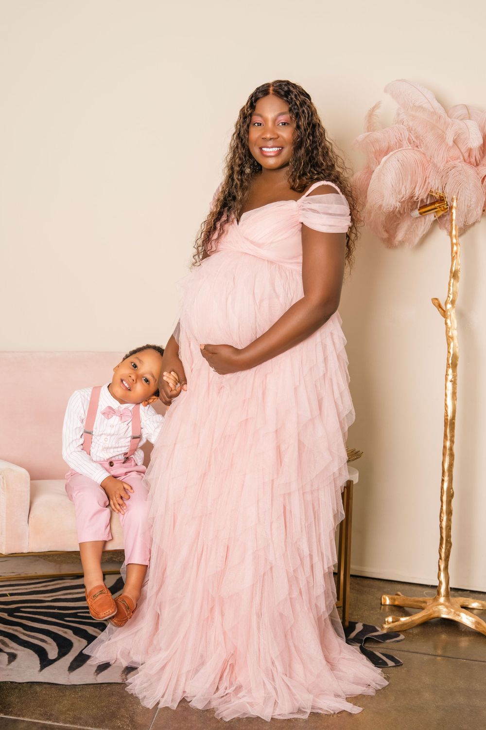 Mother and child in matching pink outfits posing for elegant portrait.