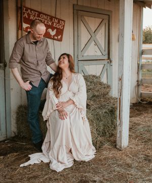 A romantic photoshoot inside a barn with vintage doors and hay-strewn floors.