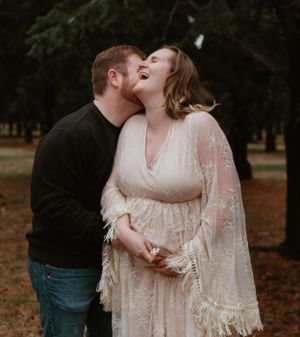 Romantic fall maternity photos with couple in white lace dress and casual wear.