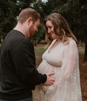 Emotional maternity photo series capturing intimate moments between couple in nature.