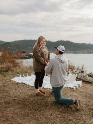 People celebrating on coastal clifftop with ocean view in background.