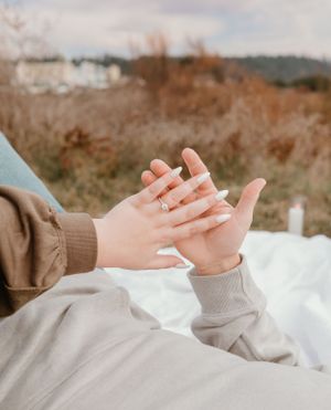 Close-up shot of hands against white fabric during an outdoor photoshoot.