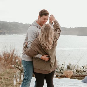 A couple embracing by the ocean during a romantic coastal photoshoot.