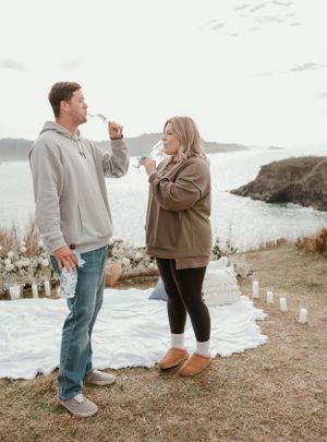 A couple enjoying champagne together during a seaside celebration.