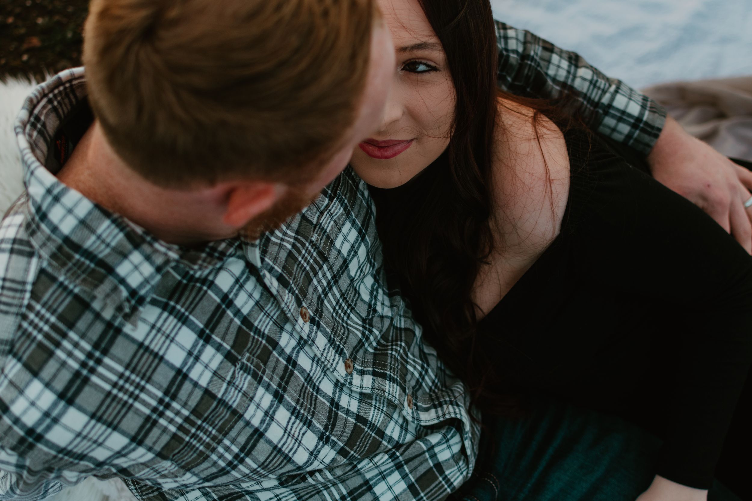 A romantic couple shares tender moments in a natural outdoor setting.