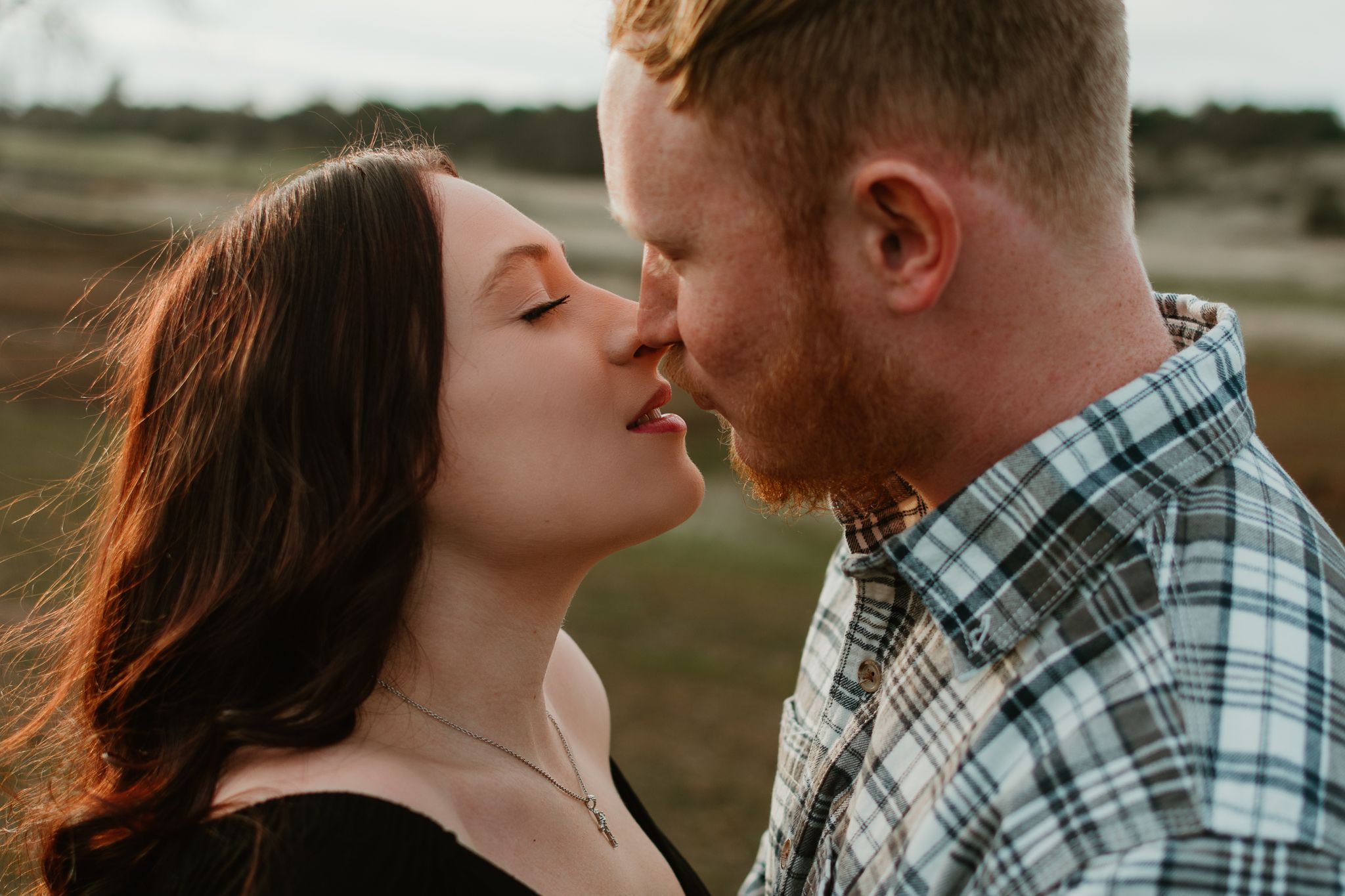 Intimate couple's portrait against natural outdoor setting.