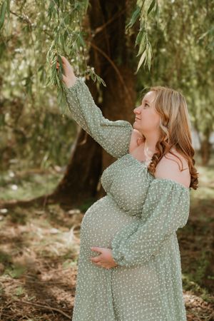 A flowing mint green dress twirls beautifully in a wooded setting.