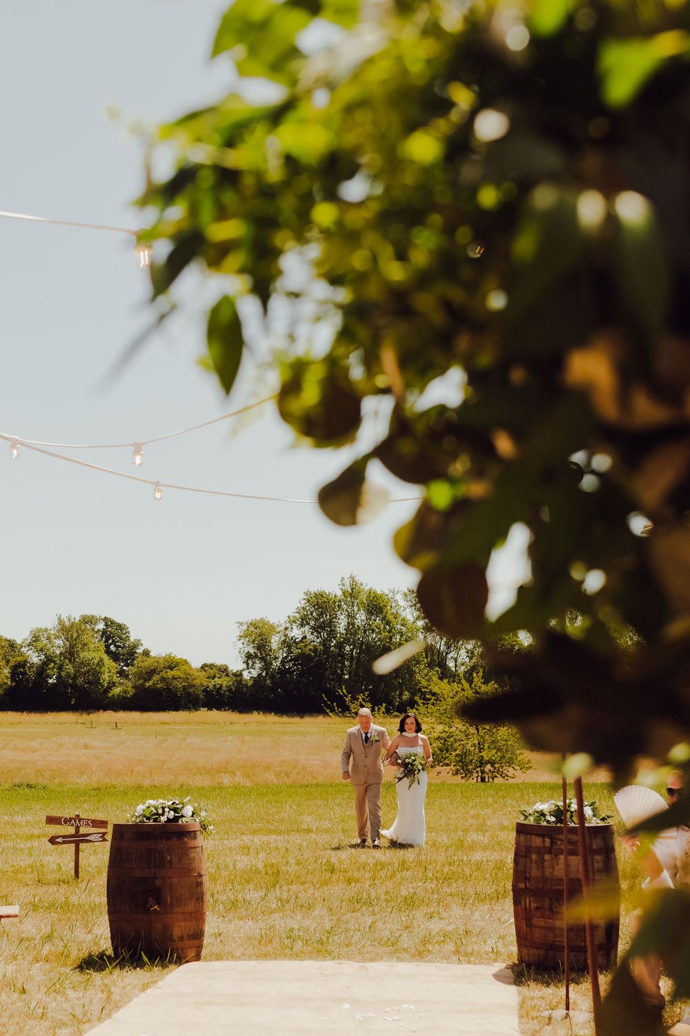 Bride walking down the aisle with her father at their outdoor wedding in Romsey
