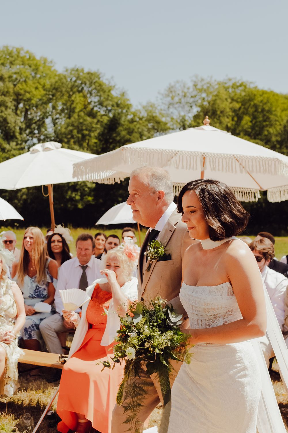 Bride Amy walking down the aisle with her father at their outdoor wedding in Romsey.