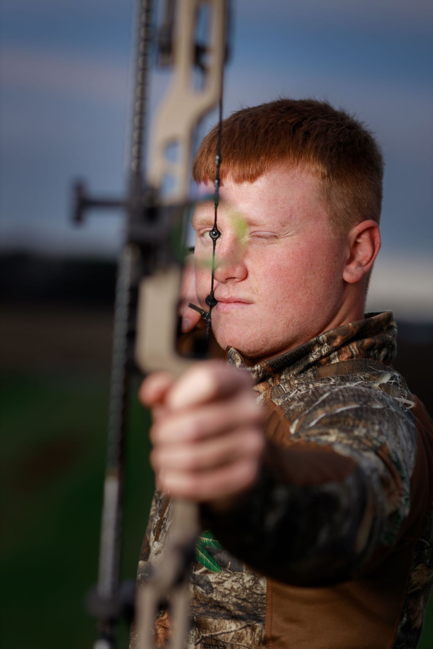 Neoga High School senior man with his bow stand for a dramatic senior picture.