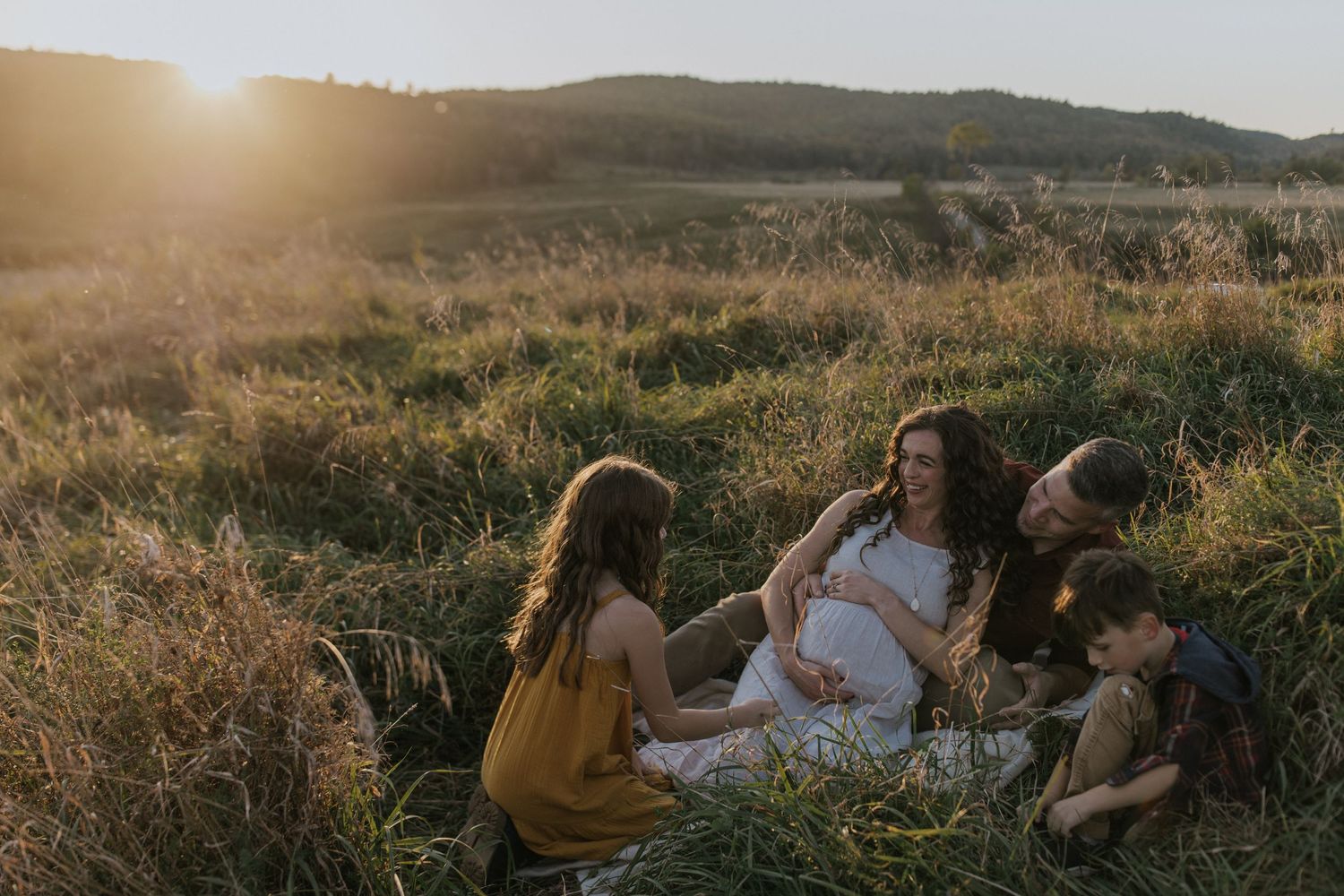 Family lifestyle portraits in a golden meadow at sunset showing natural connections.