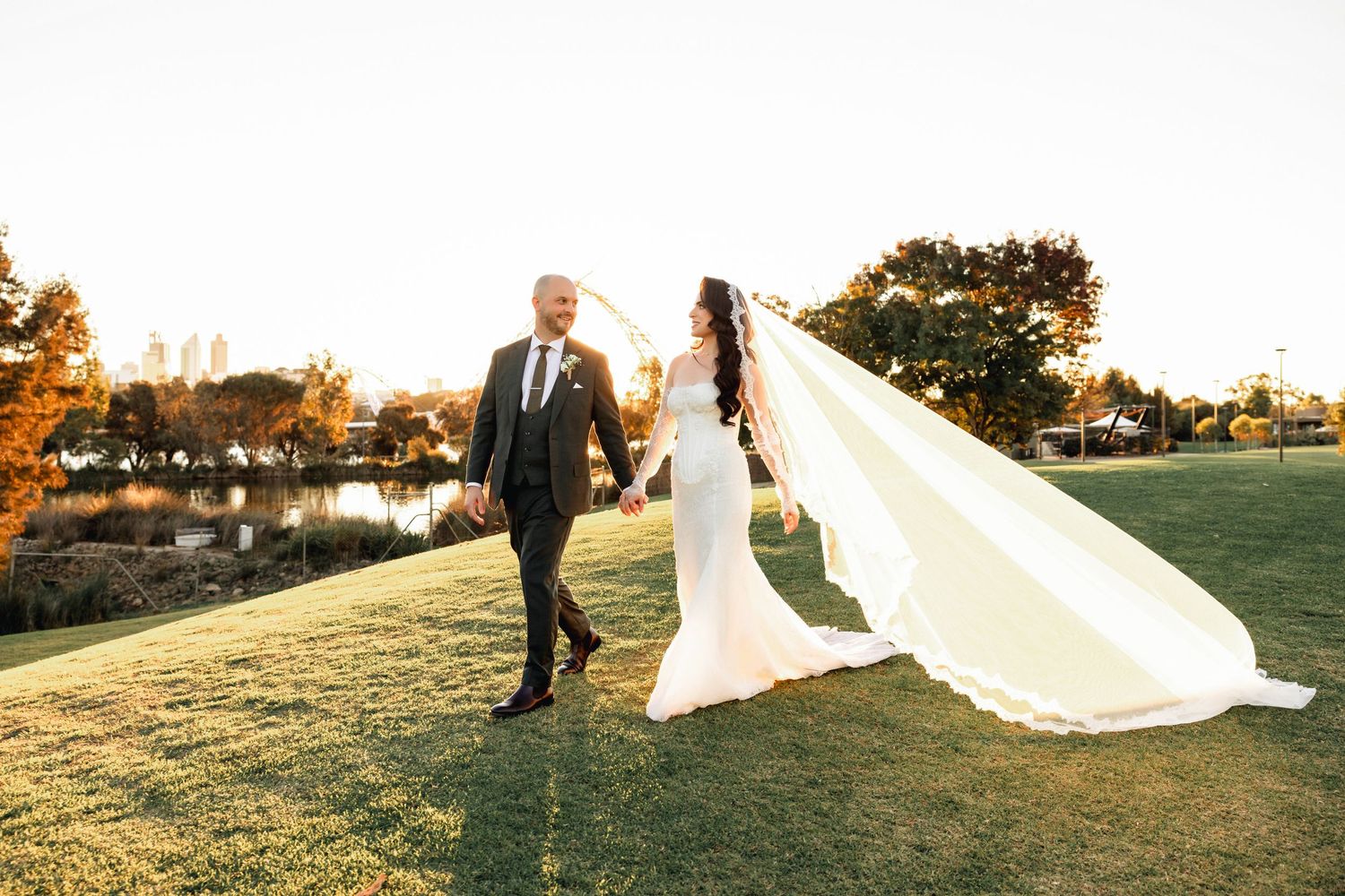 A wedding party walks through an eucalyptus forest with groomsmen following behind.