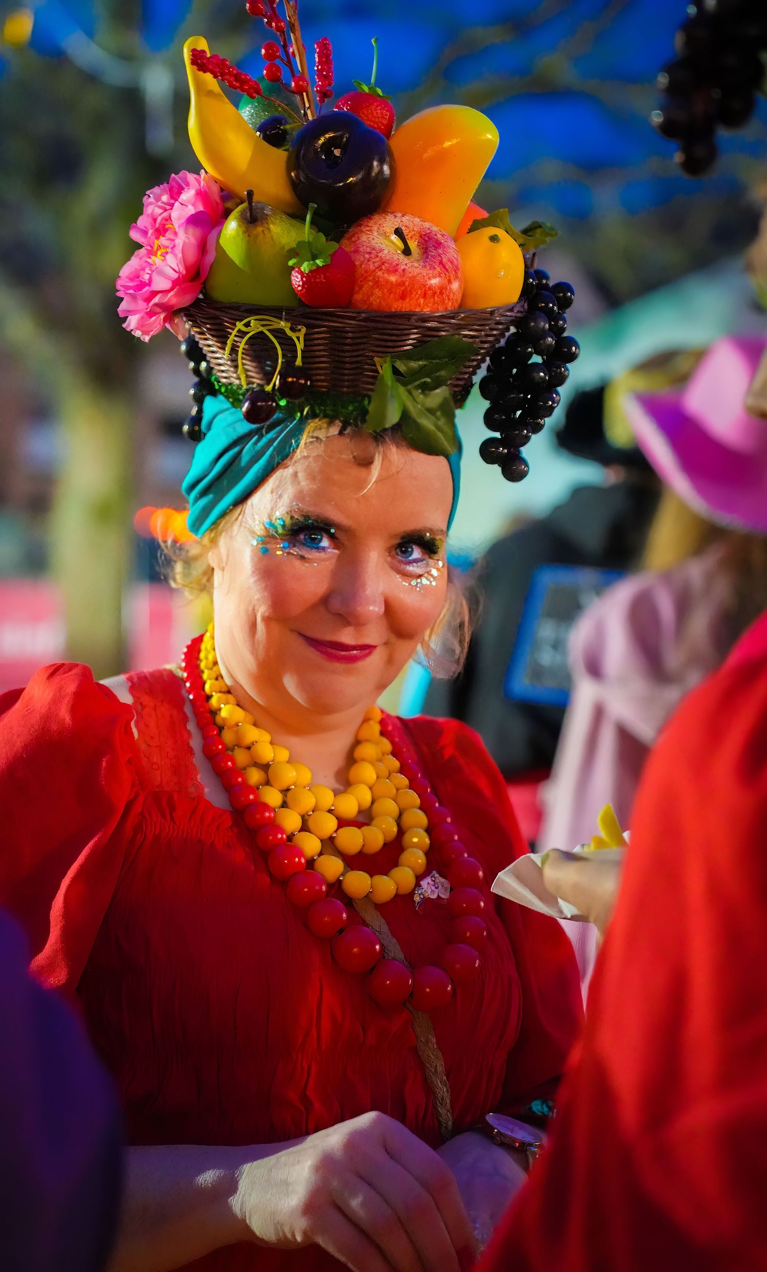 Vibrant portrait of a person in a detailed red, blue, and yellow carnival costume and decorated hat. Carnaval in Straelen. Altweiber vivitu