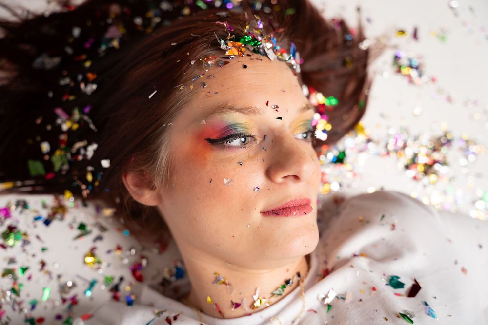 Artistic close-up portraits with scattered glitter and confetti effects.