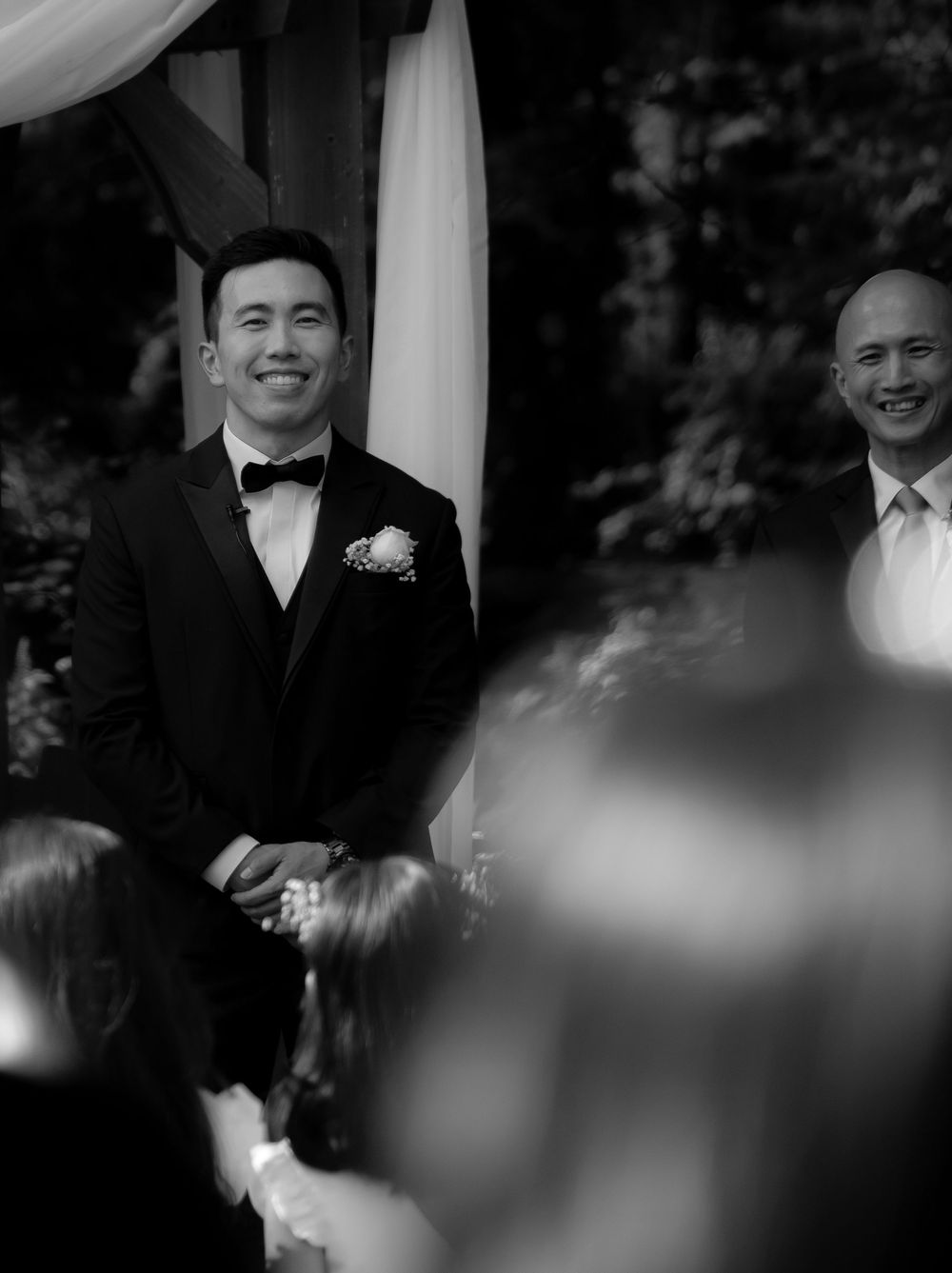 Wedding ceremony scene at an outdoor venue with formal attire and floral decorations.