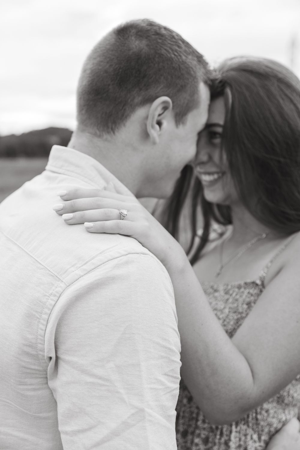Romantic couple sharing an intimate moment in white clothing outdoors.