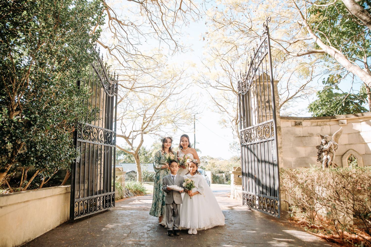 Couple exits through grand iron gates at elegant stone venue.