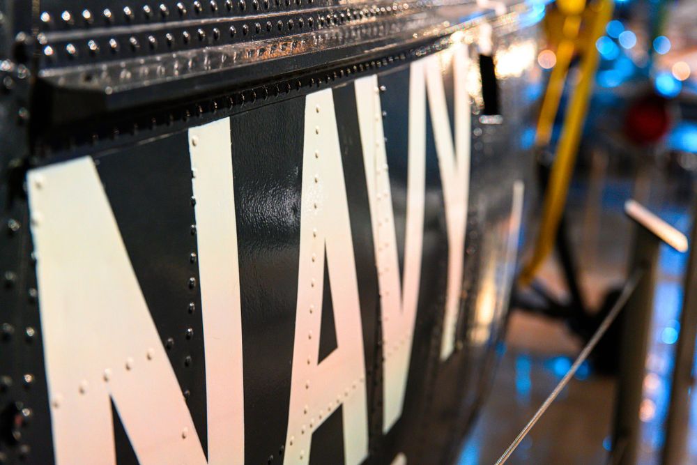 Close-up detail of text markings on black aircraft fuselage.