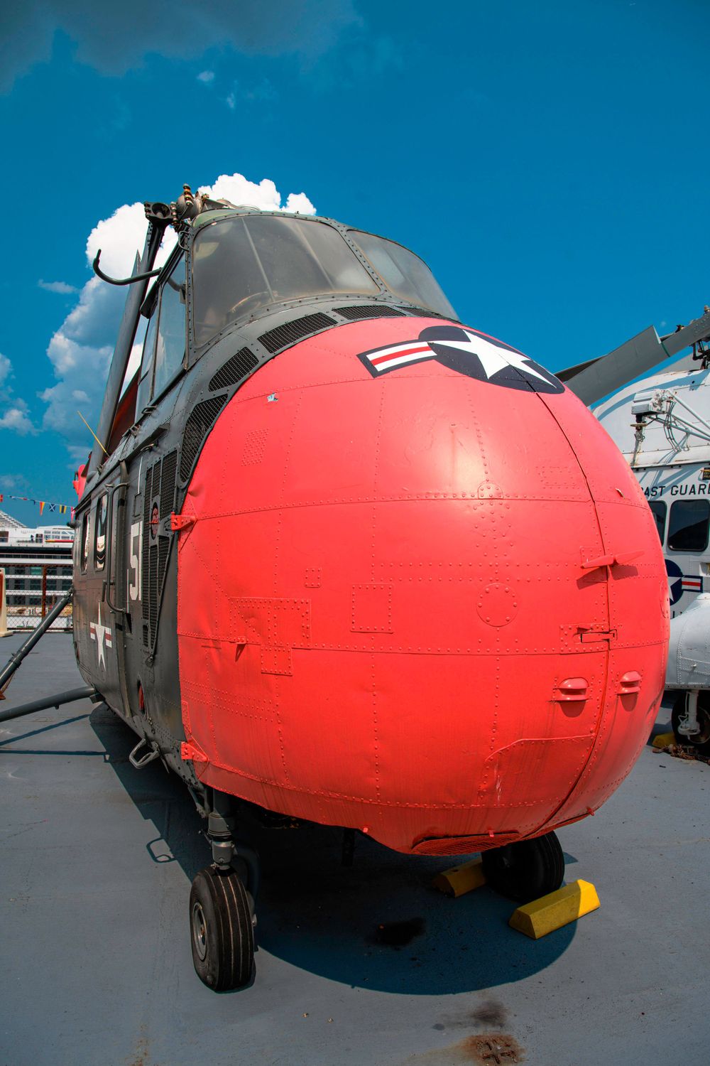 Close-up view of red helicopter nose cone with military markings.