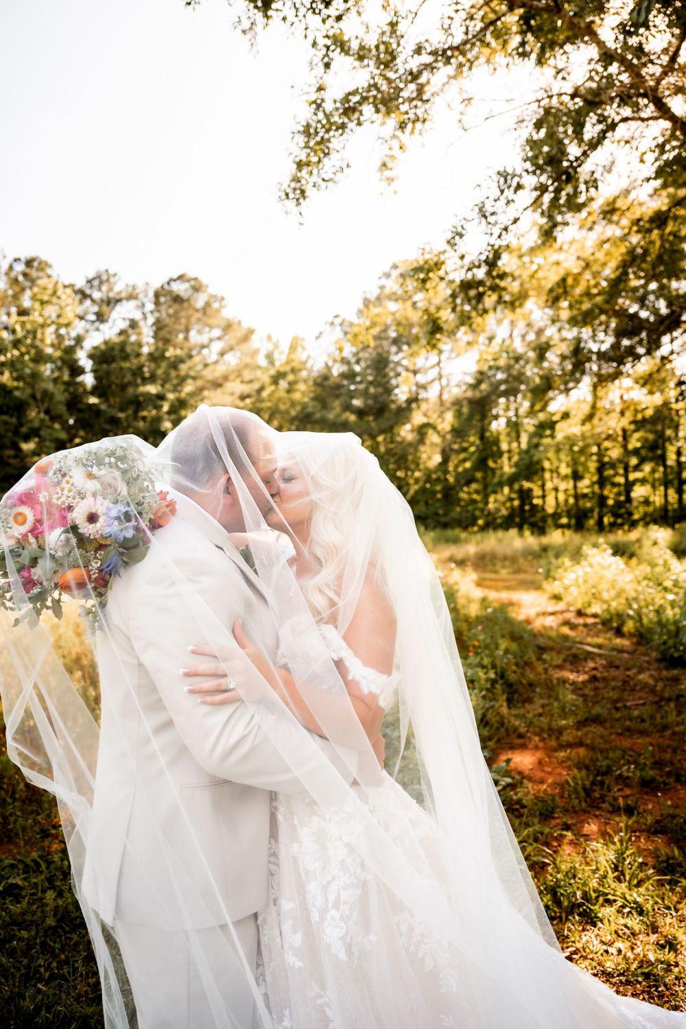 Romantic wedding portraits in golden hour light with flowing veil.