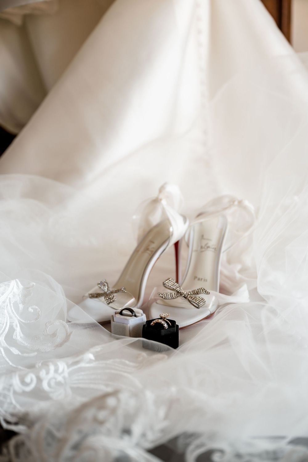 Wedding shoes peeking out from beneath layers of white tulle and lace. wedding details photography