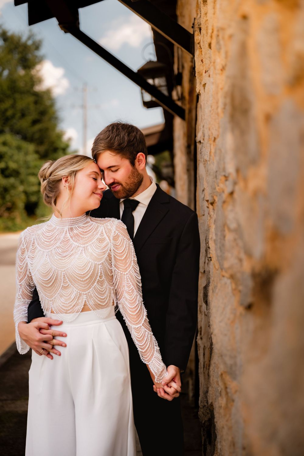 Intimate wedding portraits against weathered architecture with soft natural lighting.