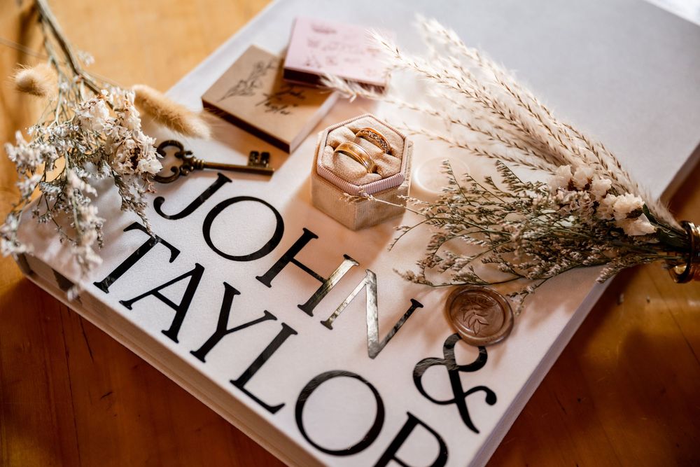 Wedding detail flatlay with vintage signage and dried floral elements on wooden surface.