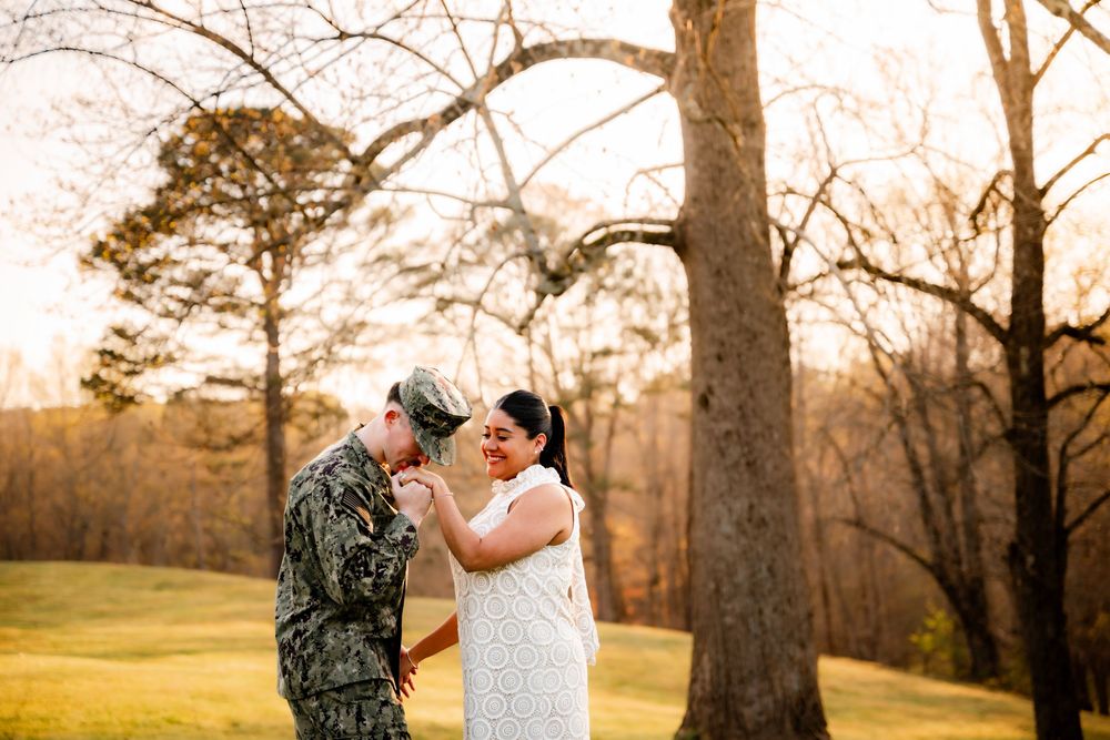 A couple shares an intimate moment in a golden sunset-lit wooded area during their wedding celebration.