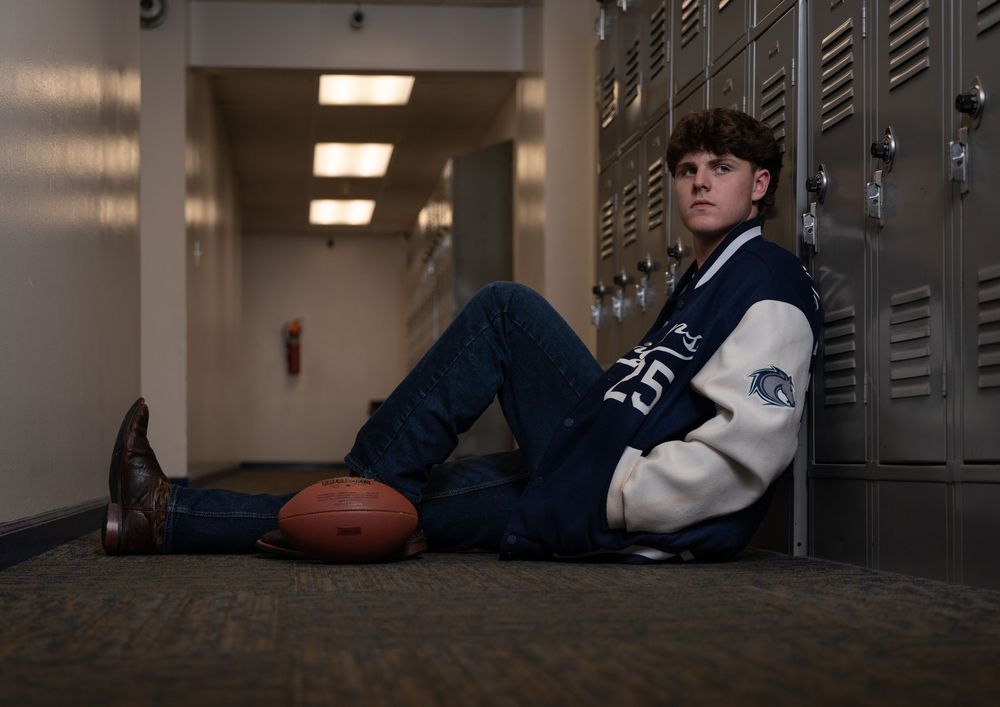 senior portrait of young man in letterman jacket