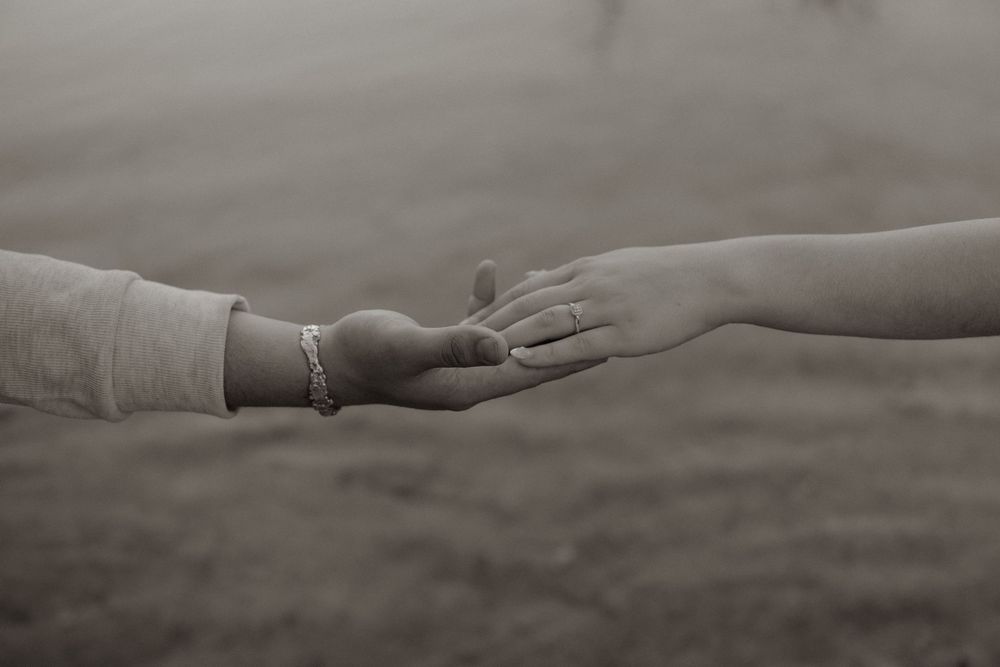 Engaged couples gently holding hands featuring her engagement ring in Fort Worth Texas