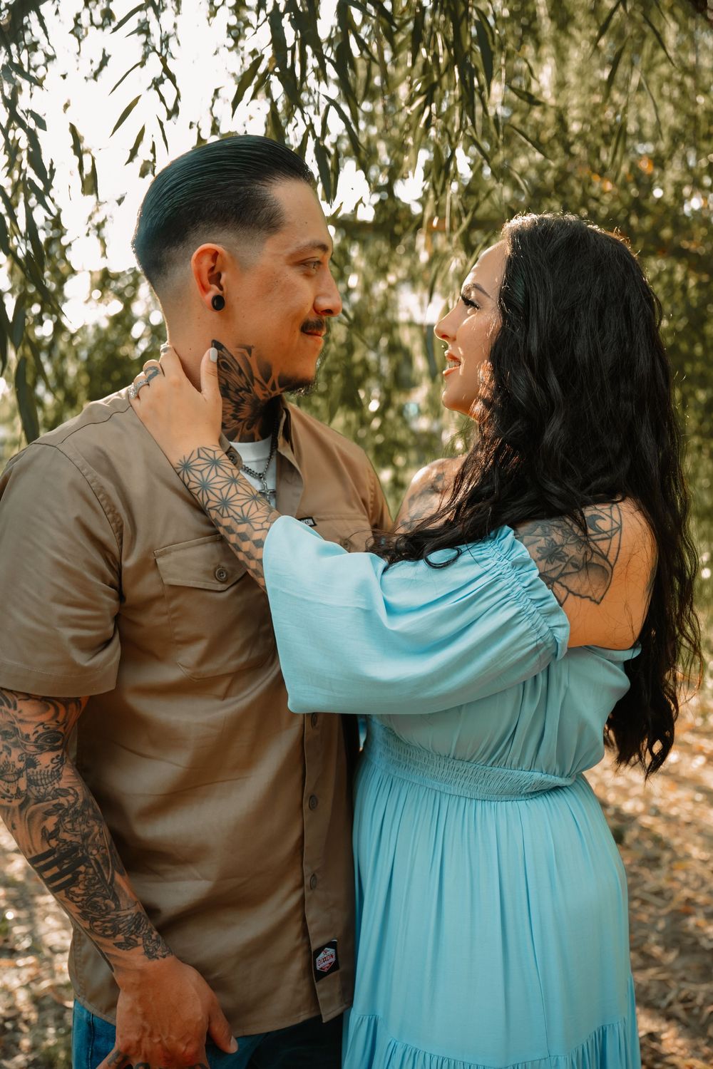 Soft light under a willow tree and couple gazing in each others eyes in DFW during family session