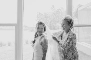 Two people share a candid moment by bright windows.