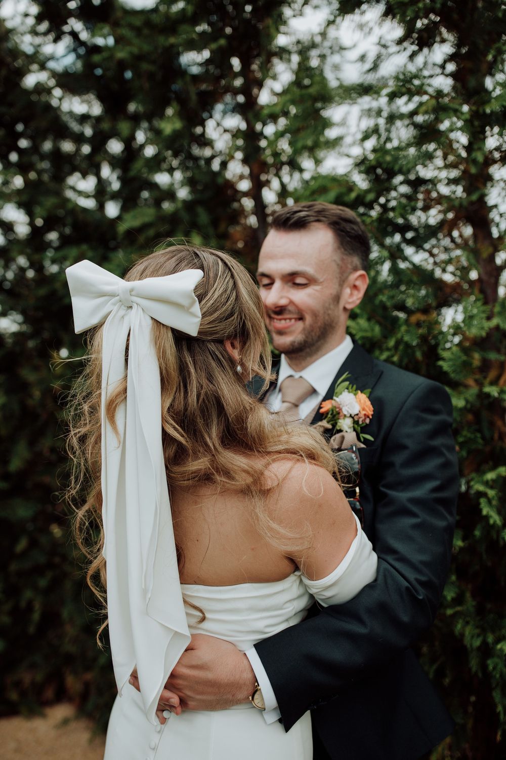 A romantic wedding photo sequence showing close-up moments of embrace between newlyweds with lovely white dress bow details.