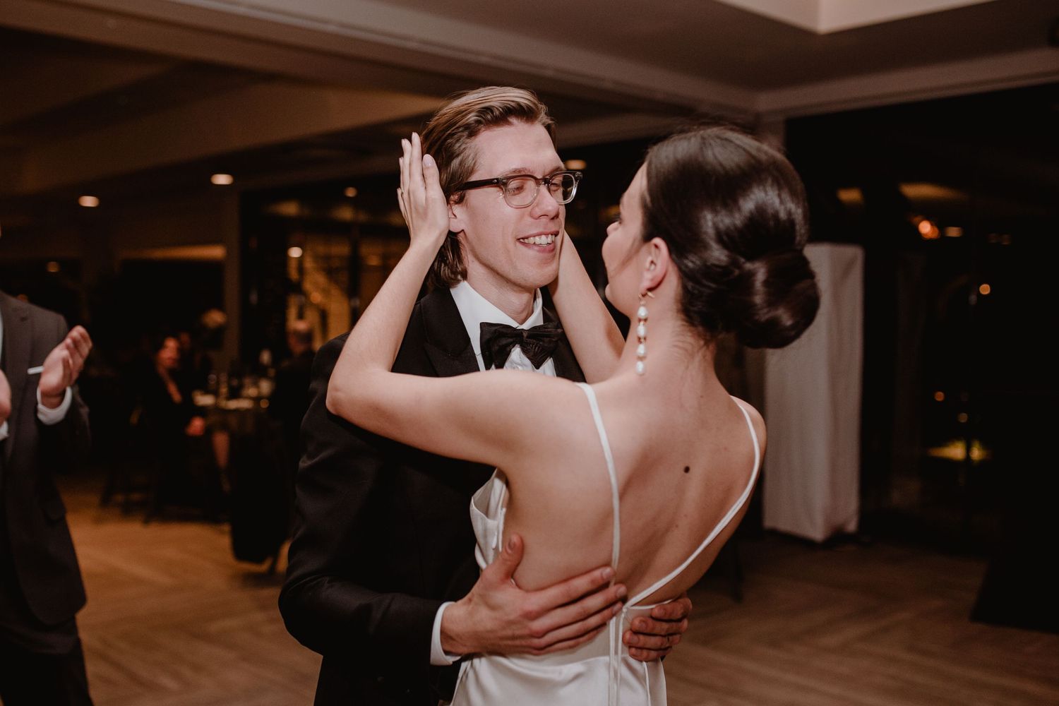 A dancing couple shares an intimate moment on the dance floor during their wedding reception.
