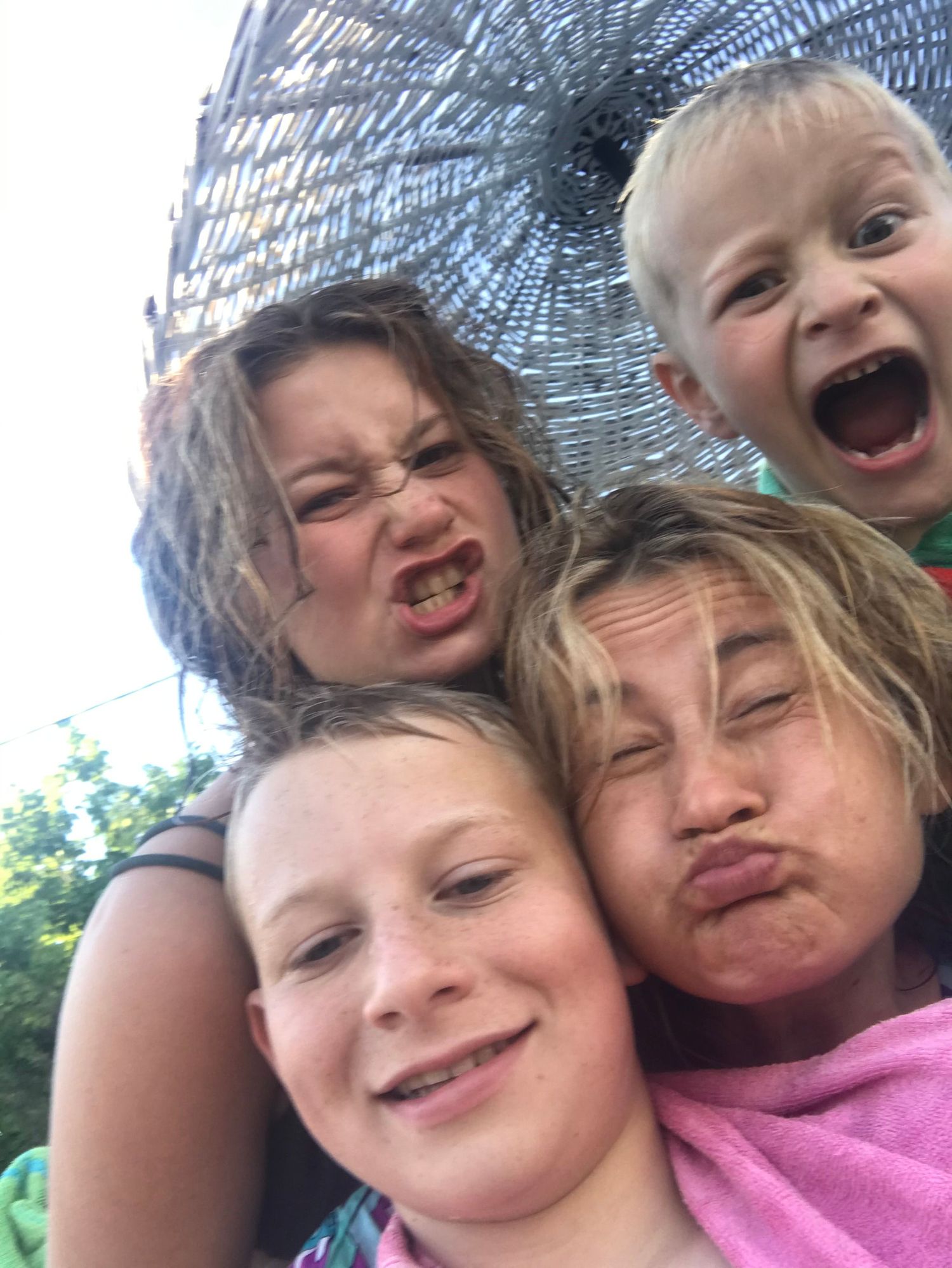 Playful selfie taken under an umbrella with silly expressions.