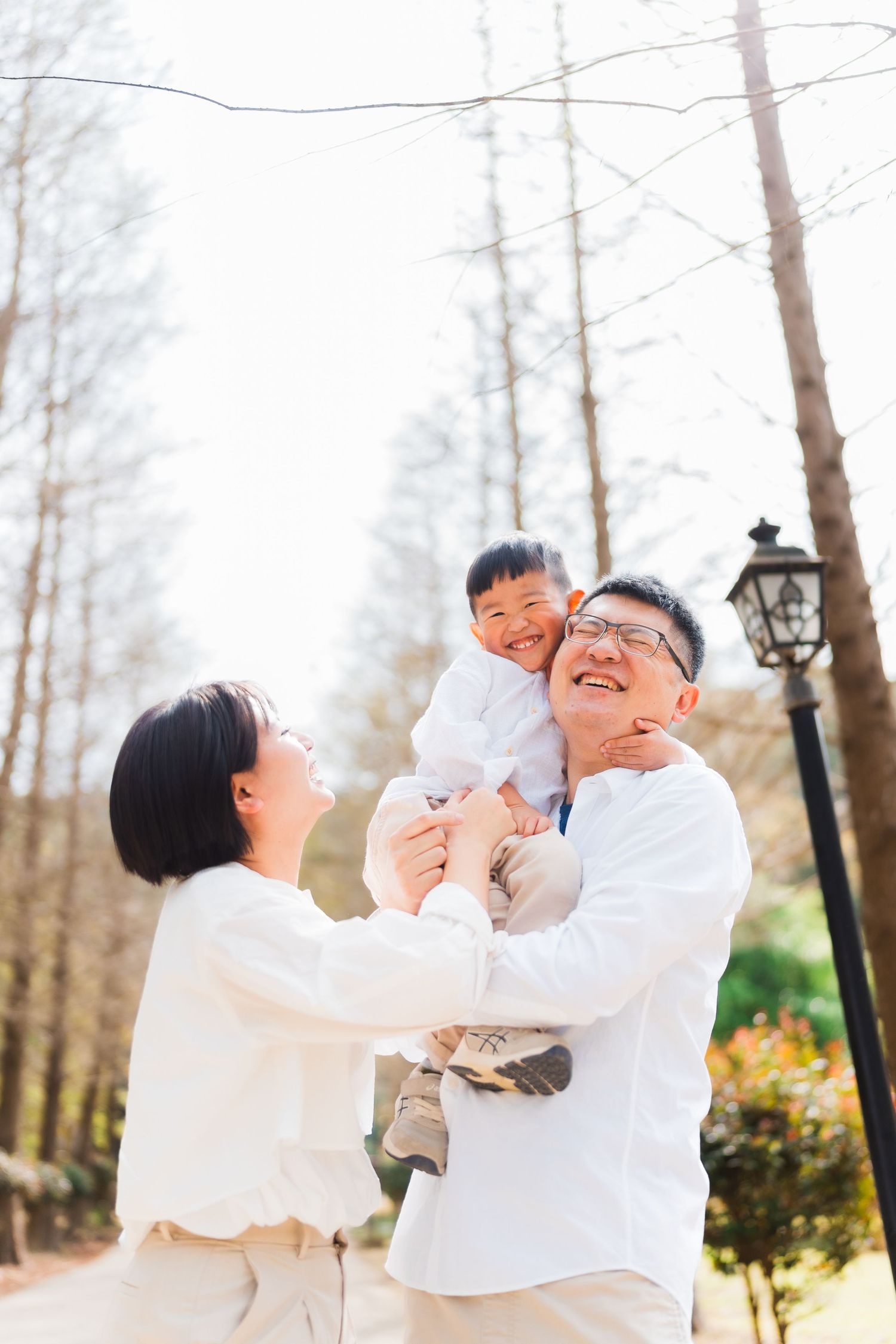 Family enjoying playful moment together in winter forest setting.