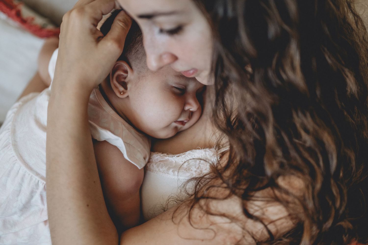 Madre con sus bebé recién nacido durmiendo en su pecho en una sesión de recién nacido en el hogar en Tandil