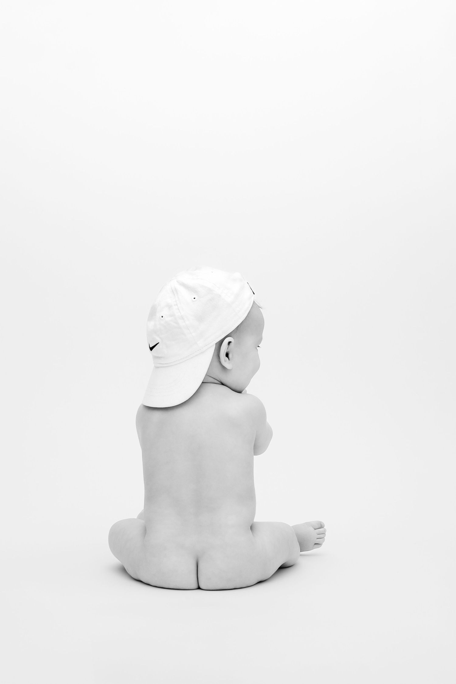 A series of minimalist black and white photographs showing a sleeping baby in different poses.