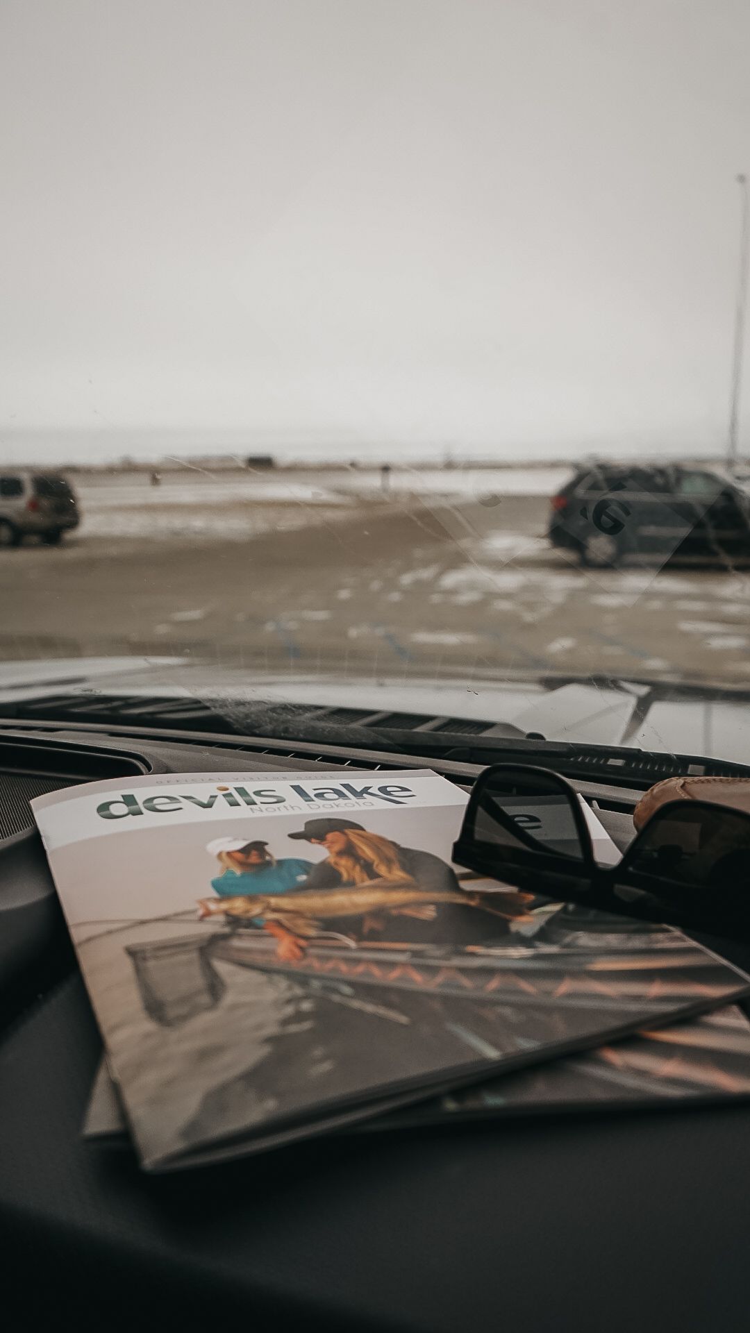 Devils Lake promotional materials displayed on a car dashboard.