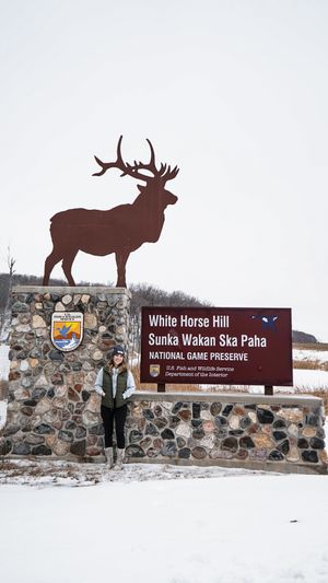 National Game Preserve entrance sign with elk silhouettes in winter setting.
