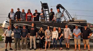 Large group of people lined up outdoors for a fishing tournament photo.