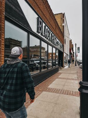 Empty small town sidewalk with brick buildings and storefronts.